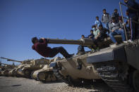 Students climb on a tank during a ceremony marking the annual Memorial Day to remember fallen soldiers and victims of terror, at the Armored Corps memorial site in Latrun, Israel, Wednesday, April 14, 2021. (AP Photo/Oded Balilty)