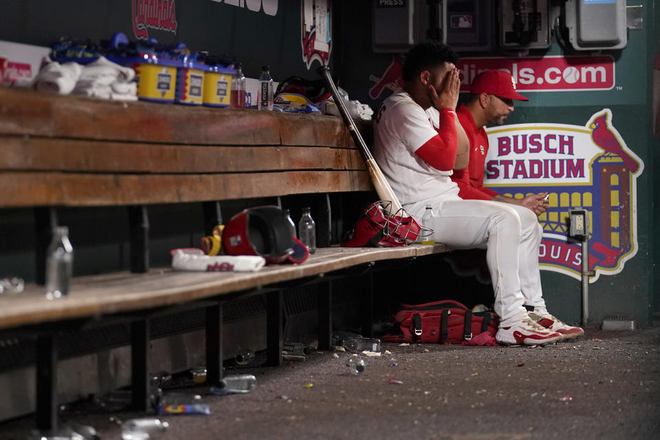 St. Louis Cardinals catcher Willson Contreras rubs his face as he talks with manager Oliver Marmol in the dugout following an 11-3 loss to the San Francisco Giants in a baseball game Tuesday, June 13, 2023, in St. Louis. (AP Photo/Jeff Roberson)