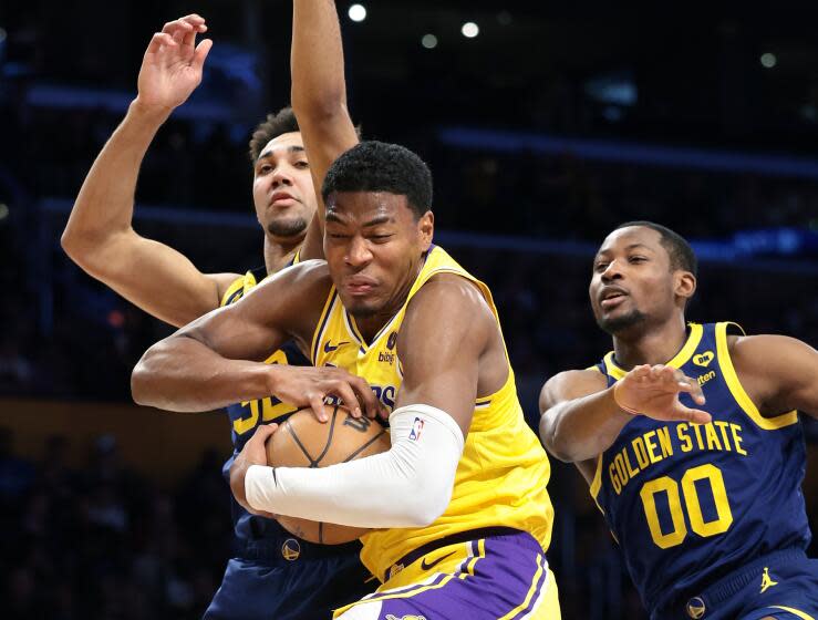 LOS ANGELES, CALIFORNIA - APRIL 9: Lakers Rui Hachimura grabs a rebound from Warriors Trayce Jackson-Davis, left, and Jonathan Kuminga in the second quarter at Crypto.com Arena Tuesday. (Wally Skalij/Los Angeles Times)