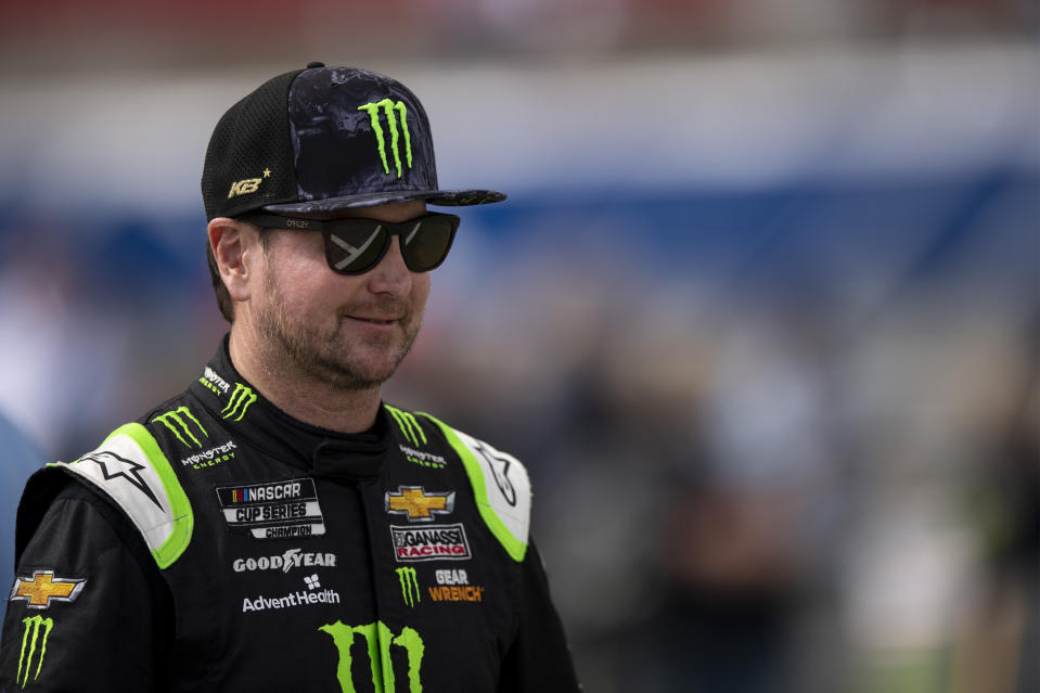 FILE - Driver Kurt Busch smiles while walking onto pit road prior to a NASCAR Cup Series auto racing race at Charlotte Motor Speedway, Sunday, Oct. 10, 2021, in Concord, N.C. Busch announced Saturday, Oct. 15, 2022, he will miss the rest of this season with a concussion and will not compete full-time in 2023. The 44-year-old made his announcement at Las Vegas Motor Speedway, his home track and where he launched his career on the bullring as a child. He choked up when he said doctors told him “it is best for me to ‘shut it down.'” (AP Photo/Matt Kelley, File)