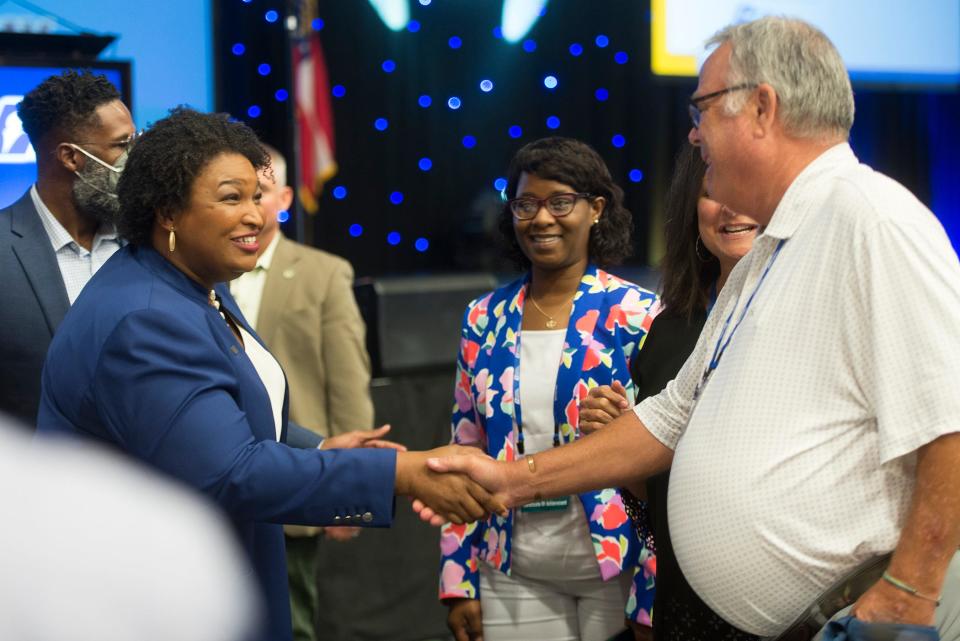 Democratic candidate for governor Stacey Abrams meets with audience members before speaking at the Georgia Municipal Association conference in the Savannah Convention Center on Monday.