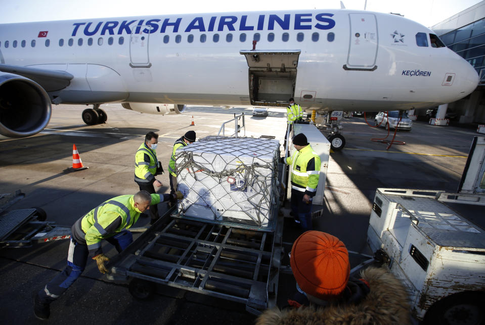 Workers unload boxes of the Astra Zeneca vaccine at the Belgrade Airport, Serbia, Sunday, Feb. 21, 2021. 150,000 doses of Astra Zeneca vaccines were delivered to Serbia. (AP Photo/Darko Vojinovic)