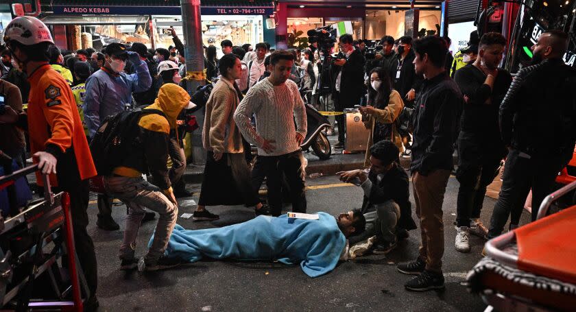 EDITORS NOTE: Graphic content / A man receives medical attention, after dozens of people suffered cardiac arrest during Halloween celebrations, in the popular nightlife district of Itaewon in Seoul on October 30, 2022. - Nearly 60 have died from a Halloween crush in Seoul, a fire department official said on October 30. (Photo by Anthony WALLACE / AFP) (Photo by ANTHONY WALLACE/AFP via Getty Images)