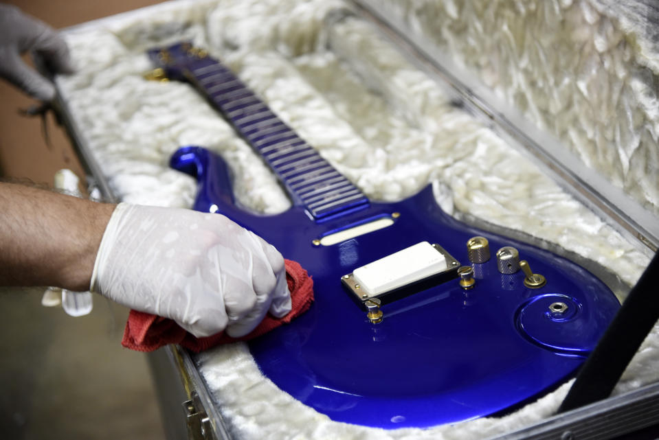 FILE - In this May 6, 2020 file photo, the “Blue Angel” Cloud 2 electric guitar custom-made for the musician Prince in the 1980s is polished at Julien's Auctions warehouse in Culver City, Calif. On Friday, June 19, 2020, the instrument shot past the top estimate of $200,000 it was expected to fetch at the Music Icons sale at the auction house. (AP Photo/Chris Pizzello)