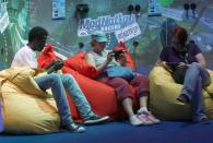 Visitors play Playstations at an exhibition stand during the Gamescom 2012 fair in Cologne August 15, 2012.
