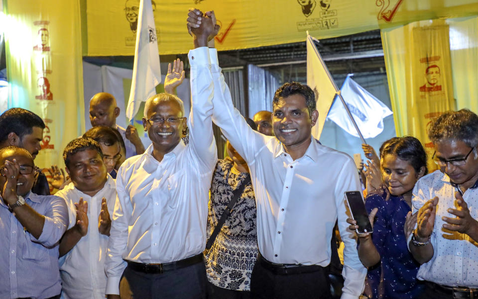 Maldives' opposition presidential candidate Ibrahim Mohamed Solih, third left, and his running mate Faisal Naseem, third right, pose for photographers as they celebrate their victory in the presidential election in Male, Maldives, Monday, Sept. 24, 2018. A longtime but little-known lawmaker, Solih declared victory at his party's campaign headquarters in a contentious election widely seen as a referendum on the island nation's young democracy.(AP Photo/Mohamed Sharuhaan)
