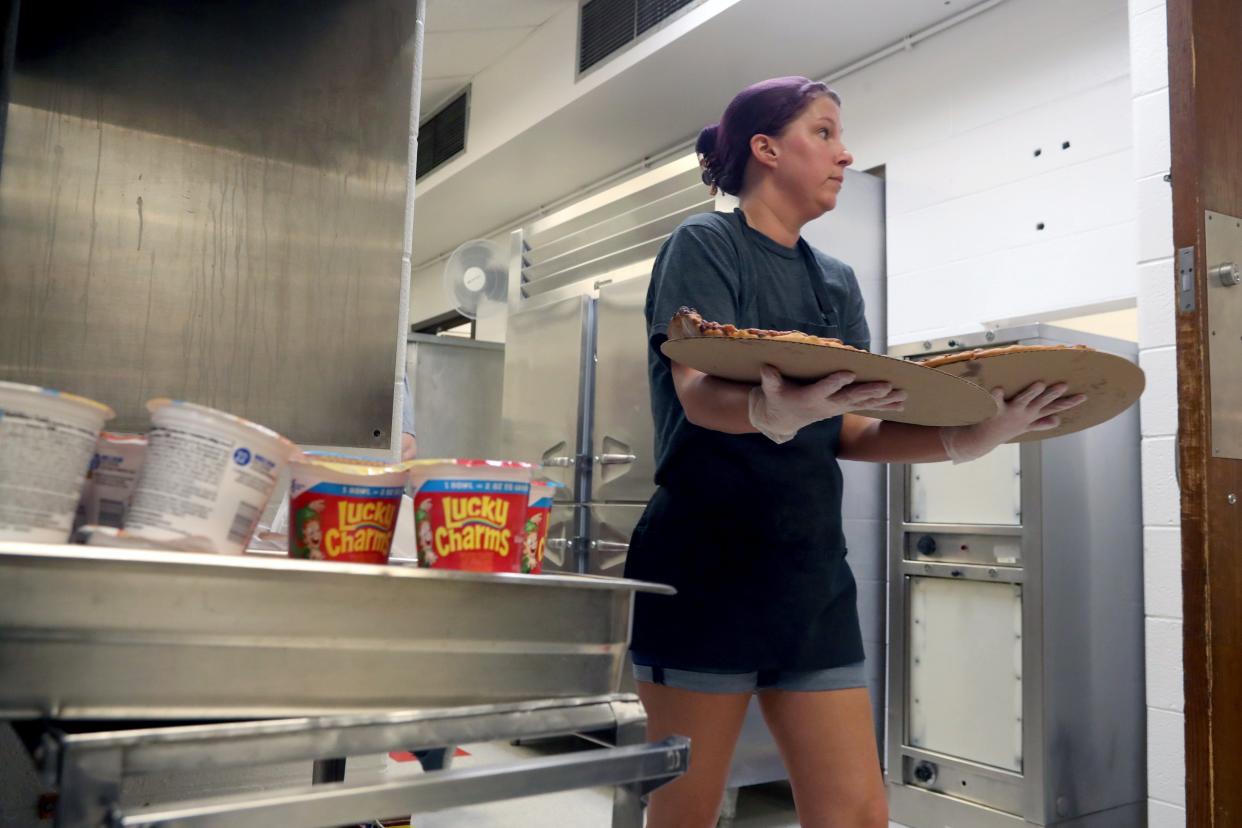 Angela Clutter, who works in food services for the South-Western City School District, brings out pizzas to the cafeteria line for students during a lunch period Jan. 19 at Grove City High School.