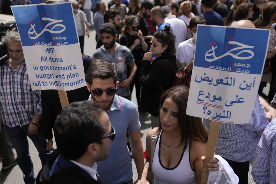 <span class="caption">Des manifestants tiennent des pancartes lors d’une manifestation contre un nouveau projet de loi sur le contrôle des capitaux qui limiterait le montant que les déposants peuvent retirer, devant le bâtiment du parlement, dans le centre de Beyrouth, le 26 avril 2022. La pancarte à droite indique : Où est la compensation pour le déposant de la livre libanaise.</span> <span class="attribution"><span class="source">(AP Photo/Hussein Malla)</span></span>