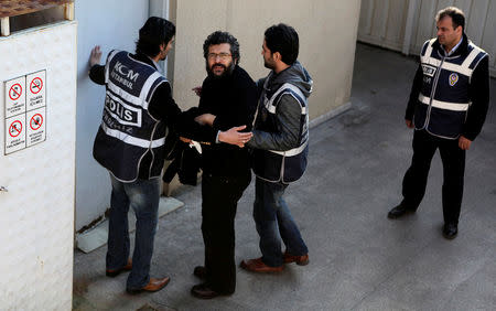 FILE PHOTO: Journalist Soner Yalcin (2nd L) is escorted by plainclothes policemen upon his arrival at a courthouse in Istanbul, Turkey, February 17, 2011. REUTERS/ Stringer/File Photo