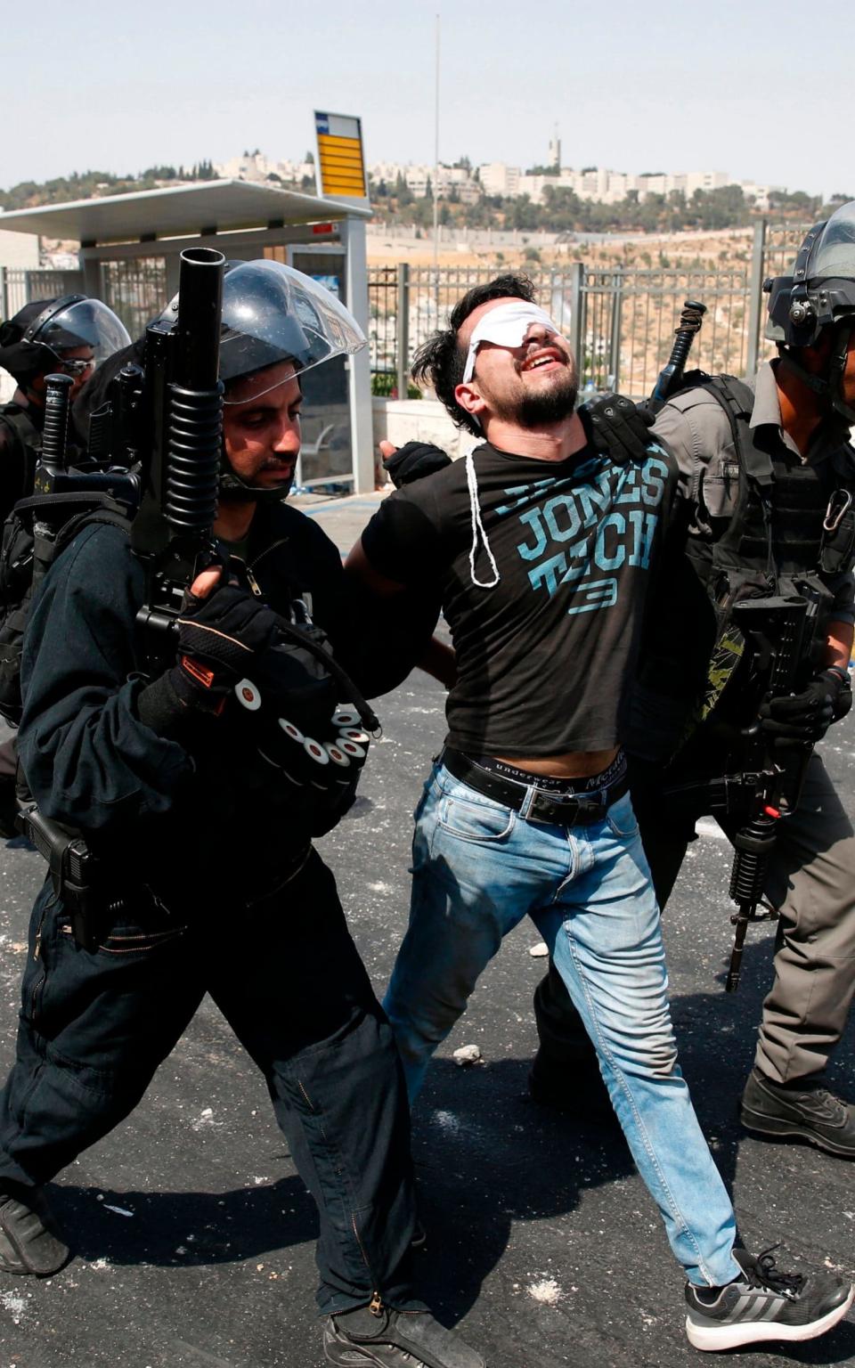 Israeli security forces detain a Palestinian protester during clashes following prayers outside Jerusalem's Old City - Credit: AFP PHOTO / AHMAD GHARABLIAHMAD GHARABLI/AFP/Getty Images