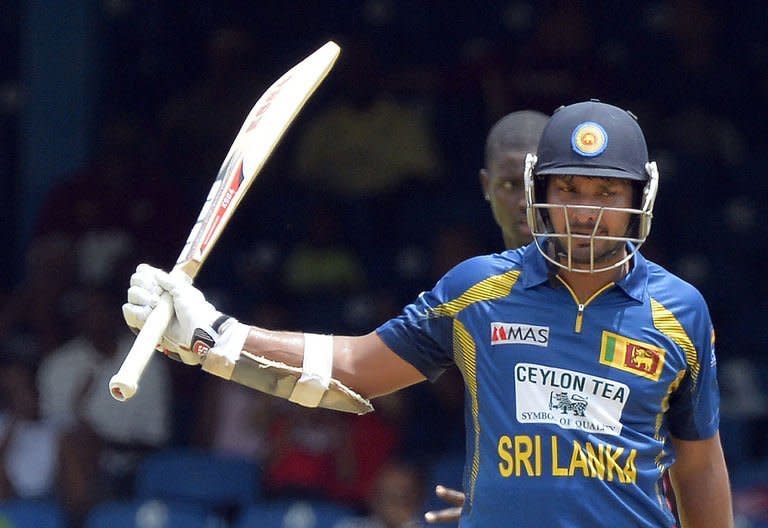 Sri Lanka's Kumar Sangakkara raises his bat after scoring his half century during the fifth match of the Tri-Nation series between Sri Lanka and West Indies at the Queen's Park Oval stadium on July 8, 2013. Sri Lanka weathered a middle-order revival by the West Indies and held on for a 39-run victory on the Duckworth/Lewis Scoring Method in a rain-affected fifth match of the Tri-Nation Series