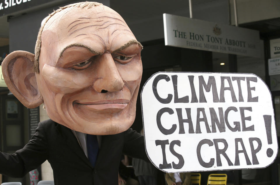 A demonstrator with a giant head in the likeness of former Australian Prime Minister Tony Abbott holds a sign referencing a comment by Abbott made in 2017 belittling the science of climate change, during a student organized protest at in Sydney, Australia, Friday, May 3, 2019. A federal election will be help on May 18.