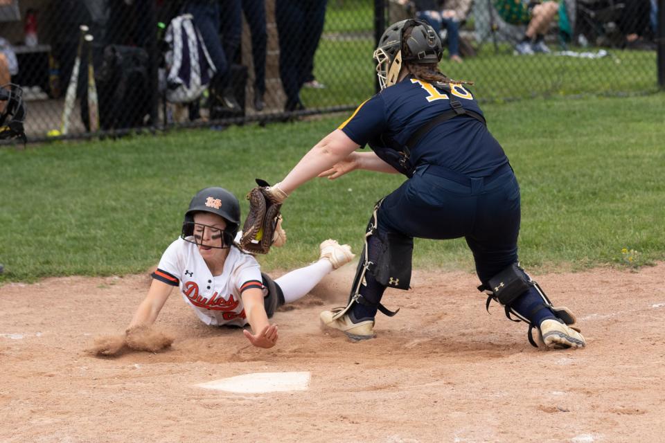 Marlboro's Kasey Conn slides in just in time under Highland's Olivia Bell.