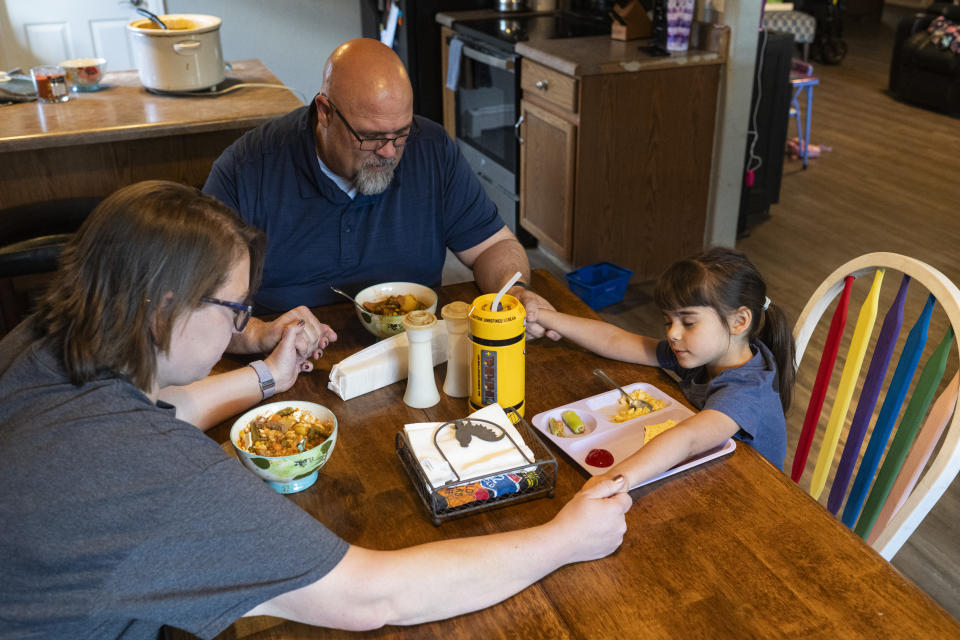 The Schroeder family prays over their meal before eating lunch. (Kelsey Brunner for The Washington Post)