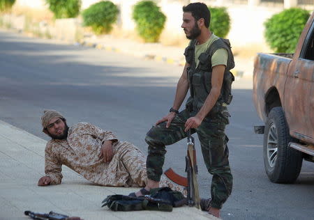 Fighters from a coalition of rebel groups called "Jaish al Fateh", also known as "Army of Fatah" (Conquest Army), rest with their weapons near Zeyzoun thermal station in al-Ghab plain in the Hama countryside July 29, 2015. REUTERS/Ammar Abdullah