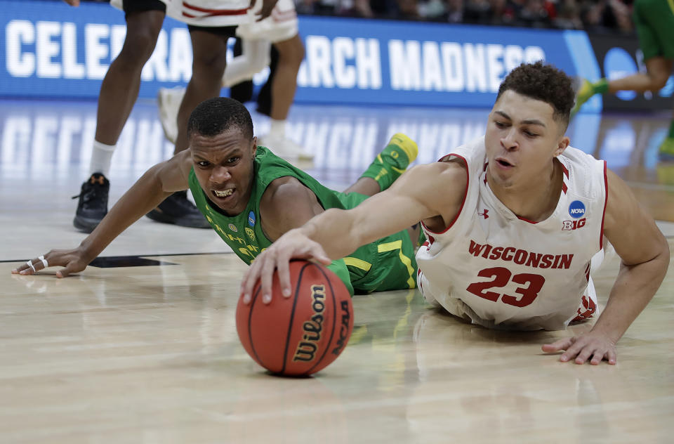 Wisconsin guard Kobe King (23) dives for the ball in front of Oregon forward Louis King during the second half of a first-round game in the NCAA men's college basketball tournament Friday, March 22, 2019, in San Jose, Calif. (AP Photo/Ben Margot)