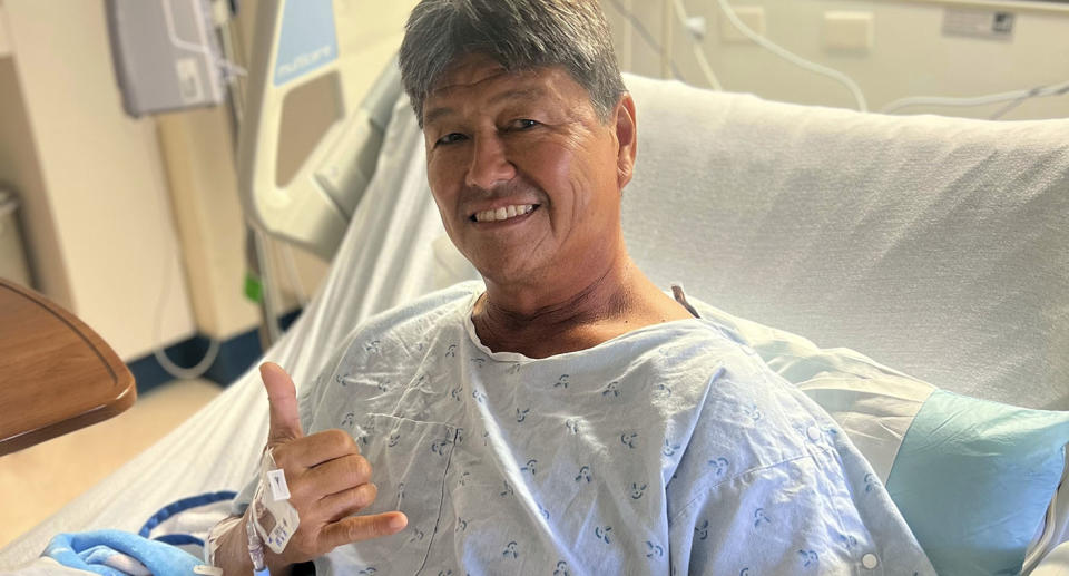 Mike Morita poses for a photo from his hospital bed, Wednesday, April 10, 2023, in Honolulu. Morita credits a faith in God for surviving an Easter Sunday shark attack and for remaining at peace despite losing his right foot. (Kamu Morita via AP)