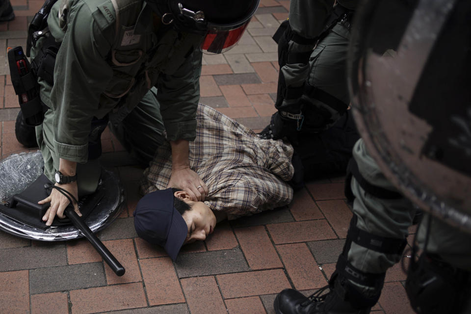 An anti government protester is detained by police at Tseun Wan, Hong Kong, Sunday, Oct.13, 2019. The semi-autonomous Chinese city is in its fifth month of a movement that initially began in response to a now-withdrawn extradition bill that would have allowed Hong Kong residents to be tried for crimes in mainland China. The protests have since ballooned to encompass broader demands for electoral reforms and an inquiry into alleged police abuse. (AP Photo/Felipe Dana)