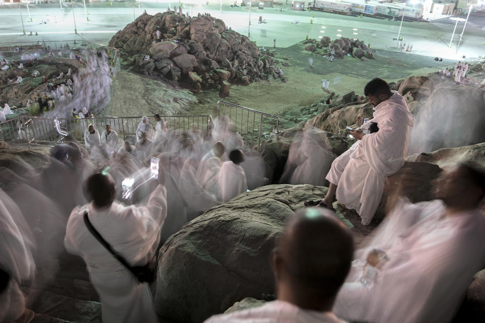 Muslim pilgrims pray on the rocky hill known as the Mountain of Mercy, on the Plain of Arafat, during the annual Hajj pilgrimage, near the holy city of Mecca, Saudi Arabia, Tuesday, June 27, 2023. Muslim pilgrims in Mecca circled the Kaaba, Islam's holiest site, and then converged on a vast tent camp in the nearby desert, officially opening the annual Hajj pilgrimage on Monday, returning to its full capacity for the first time since the coronavirus pandemic. (AP Photo/Amr Nabil)