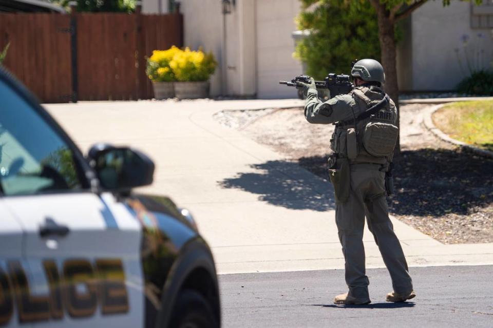 A Placer County sheriff’s deputy approaches a home on Greenbrae Road in Rocklin on Sunday, July 9, 2023, after a potential sighting of Mahany Park murder suspect Eric James Abril, who escaped earlier in the morning from a Roseville hospital.