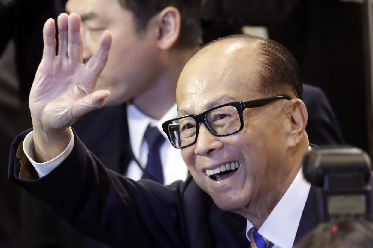 Hong Kong billionaire Li Ka-shing, chairman of CK Hutchison Holdings company, waves after a press conference to announce the company's annual results in Hong Kong, Friday, March 16, 2018. Li said Friday he is retiring as chairman of his sprawling conglomerate and handing control to his eldest son. (AP Photo/Kin Cheung)