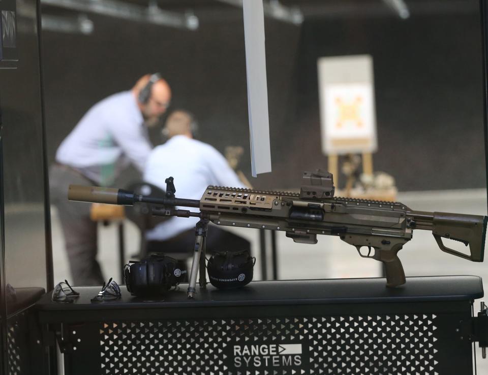 Instructor Jason St. John left, prepares a person at one of the firing ranges during the official opening of Sig Sauer's Experience Center in Epping July 13, 2022.