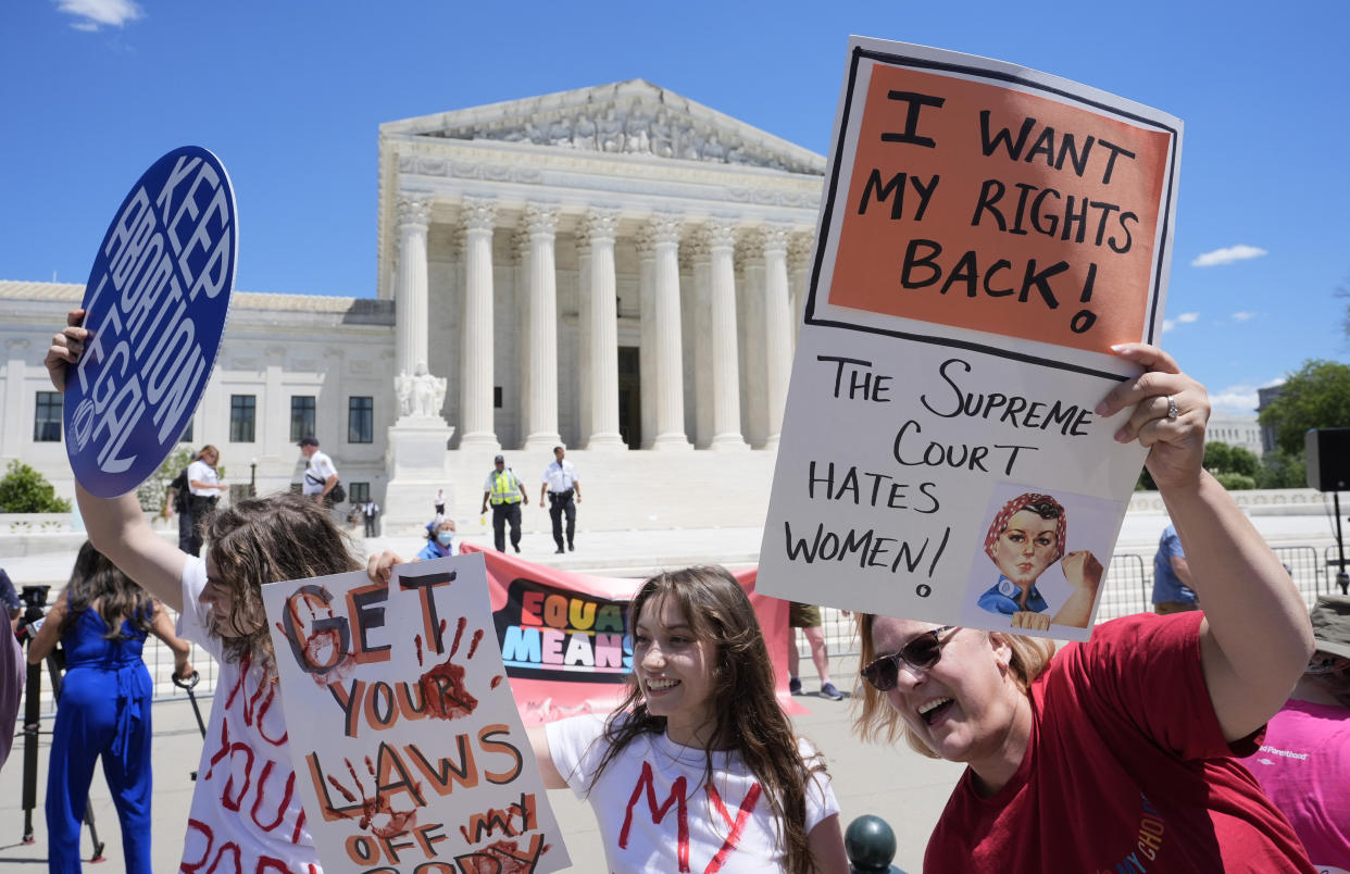 Abortion rights activists holding signs outside the Supreme Court. 