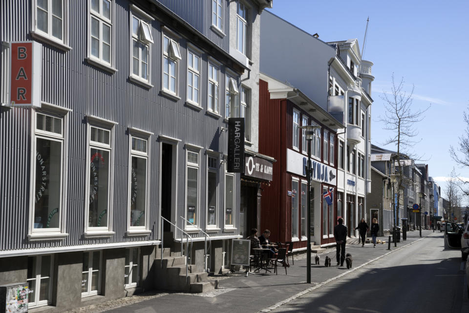 In this photo taken on Thursday, April 30, 2020, people walk down a street in downtown Reykjavik. High schools, dentists and hair salons are about to reopen in Iceland, which has managed to get a grip on the coronavirus through the world’s most extensive regime of testing. By identifying infected people even when they had no symptoms, the tiny North Atlantic nation managed to identify and isolate cases where many bigger countries have struggled. (AP Photo/Egill Bjarnason)