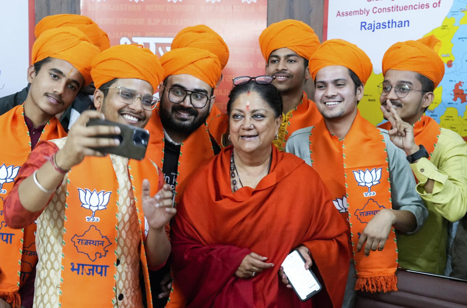 India's ruling Bharatiya Janata Party, or BJP, leader and former Chief Minister Vasundhara Raje poses for a selfie with young party workers following leads for the party in Rajasthan state elections in Jaipur, India, Sunday, Dec.3, 2023. India’s Hindu nationalist party was headed for a clear win in three out of four states Sunday, according to the election commission’s website. (AP Photo/Deepak Sharma)