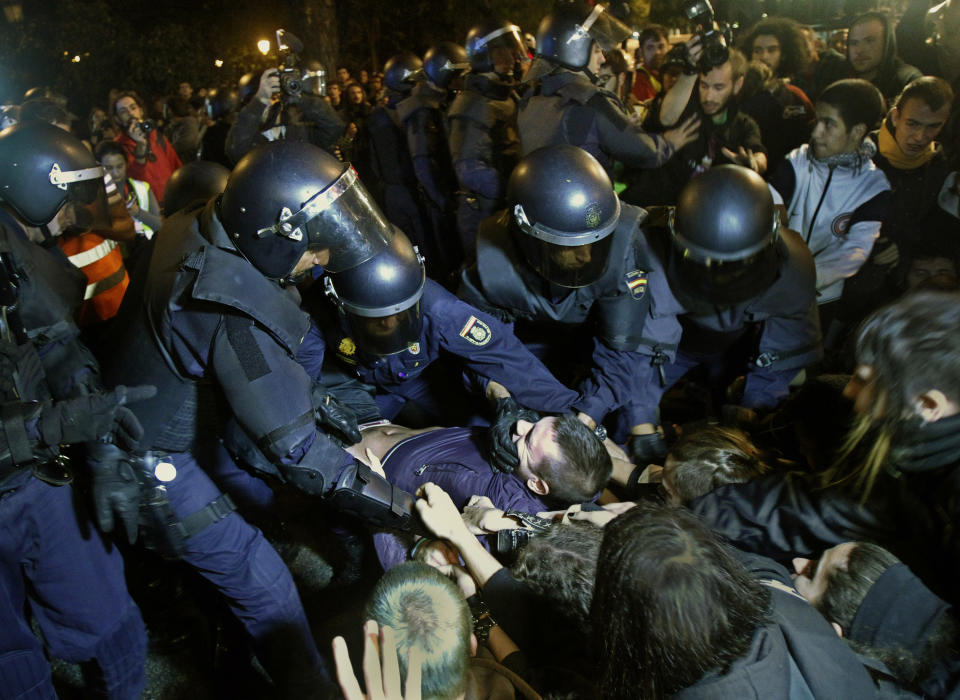 File - In this Sept. 26, 2012 file photo, police clash with protestors during a demonstration at the parliament against austerity measures announced by the Spanish government in Madrid. Spain's government said Friday Oct. 19, 2012 it is considering a ban on photographing, filming and reproducing images of police and state security forces while “in the exercise of their functions.” Deputy Prime Minister Soraya Saenz de Santamaria said that after months of television and internet viewing of sometimes violent clashes between police and demonstrators a balance had to be struck “between citizens' right to protest” and a need “to uphold the integrity of state security forces.” (AP Photo/Andres Kudacki, File)