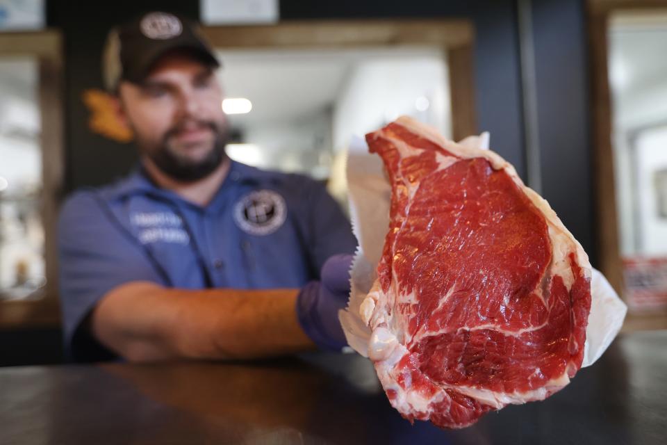 Head Chef Lee Hurley shows off a grass fed cut of bone-in ribeye steak, sold from the farm store at Home Place Pastures on Friday, July 23, 2021. 