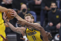 Indiana Pacers forward Domantas Sabonis (11) pulls down an offensive rebound over Charlotte Hornets center Bismack Biyombo in the first half of an NBA basketball game in Charlotte, N.C., Wednesday, Jan. 27, 2021. (AP Photo/Nell Redmond)