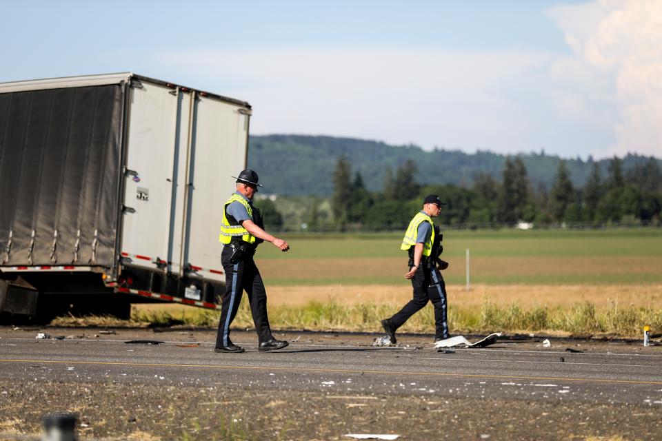 Two Oregon State Police officers walk along northbound Interstate 5 where seven people were killed in a three-vehicle crash on Thursday, May 18 in Marion County.