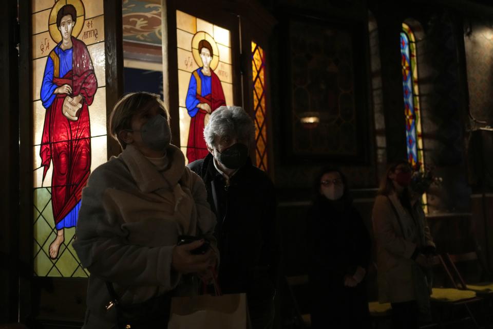 Faithful wearing face masks to curb the spread of coronavirus, attend a church service in Athens, Greece, on Monday, April 18, 2022. For the first time in three years, Greeks were able to celebrate Easter without the restrictions made necessary by the coronavirus pandemic. (AP Photo/Thanassis Stavrakis)