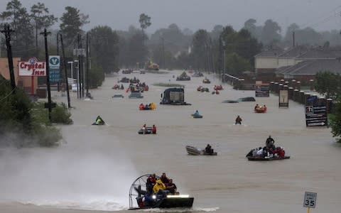 Residents use boats to evacuate flood waters from Tropical Storm Harvey along Tidwell Road east Houston - Credit: REUTERS
