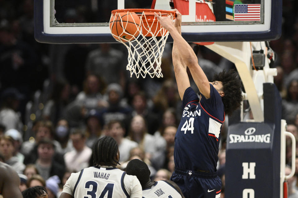 Connecticut guard Andre Jackson Jr. (44) scores a basket against Georgetown center Qudus Wahab, bottom, left, and forward Akok Akok, bottom right, during the second half of an NCAA college basketball game, Saturday, Feb. 4, 2023, in Washington. Connecticut won 68-62. (AP Photo/Nick Wass)