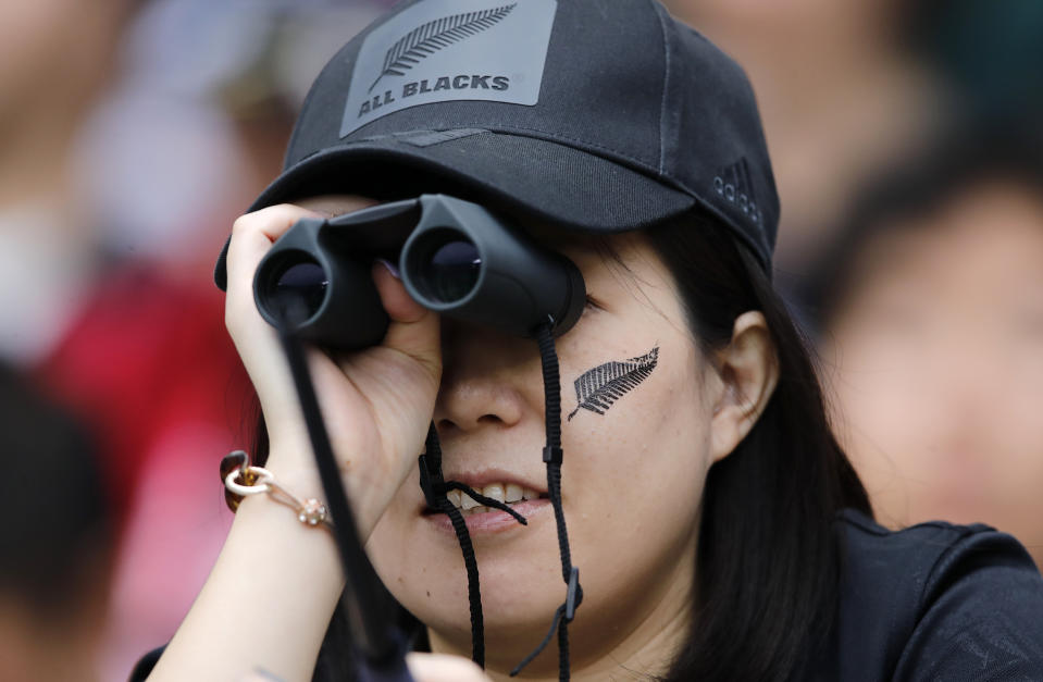 New Zealand All Blacks fan watches her team warm up ahead of the Rugby World Cup Pool B game at Tokyo Stadium between New Zealand and Namibia in Tokyo, Japan, Sunday, Oct. 6, 2019. (AP Photo/Christophe Ena)