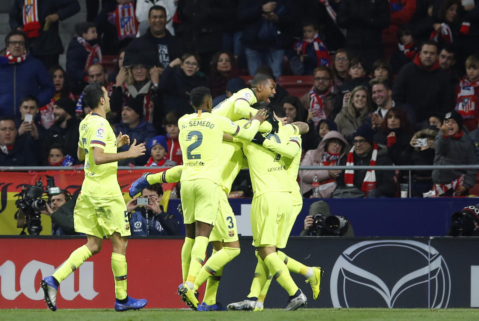 Barcelona players celebrate after Ousmane Dembele scored their first goal during a Spanish La Liga soccer match between Atletico Madrid and FC Barcelona at the Metropolitano stadium in Madrid, Saturday, Nov. 24, 2018. (AP Photo/Paul White)