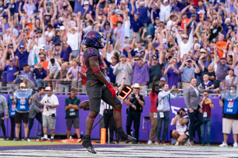 TCU running back Kendre Miller (33) celebrates after scoring the game winning touchdown during the second overtime period ofa  43-40 win against OSU on Saturday in Fort Worth, Texas.