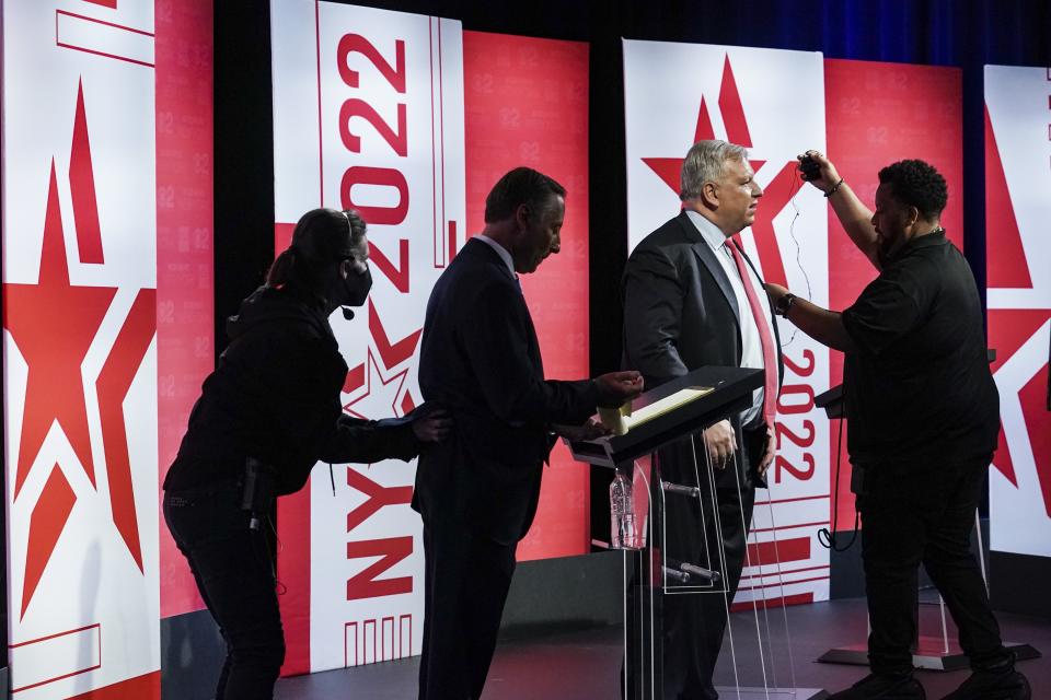 Former Westchester County Executive Rob Astorino,second from left, and businessman Harry Wilson, second from right, have their mics removed after participating in New York's Republican gubernatorial debate at the studios of CBS2 TV, Monday June 13, 2022, in New York. (AP Photo/Bebeto Matthews)