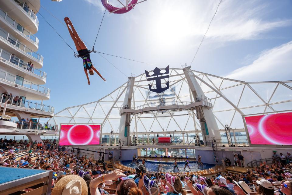 acrobats in the air above a theater filled with people