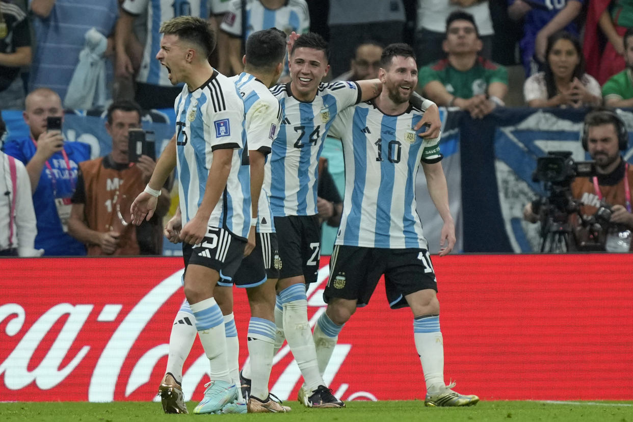 Argentina&#39;s Enzo Fernandez, second from right, celebrates with his teammate Lionel Messi, right, during the World Cup group C soccer match between Argentina and Mexico, at the Lusail Stadium in Lusail, Qatar, Saturday, Nov. 26, 2022. (AP Photo/Jorge Saenz)