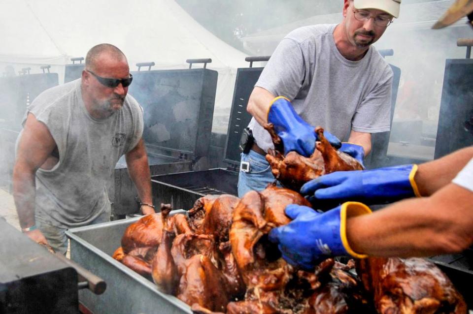 In this Journal Star file photo from 2013, volunteers take cooked turkeys off the grill at the Tremont Turkey Festival.