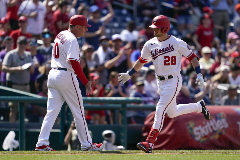 Washington Nationals' Lane Thomas, right, rounds the bases past third base coach Gary Disarcina after hitting a two-run home run in the sixth inning of a baseball game against the Colorado Rockies, Sunday, May 29, 2022, in Washington. (AP Photo/Patrick Semansky)