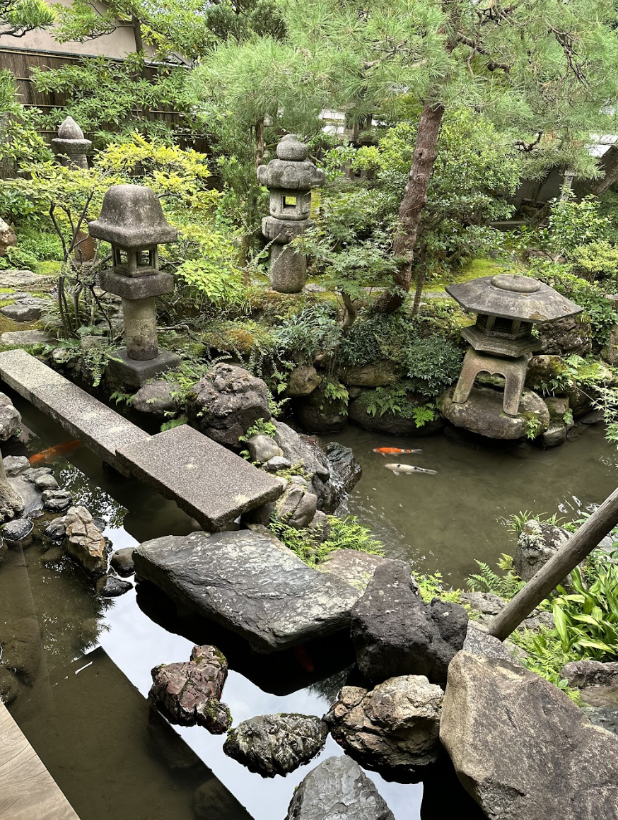 a pond with rocks and a structure in the middle