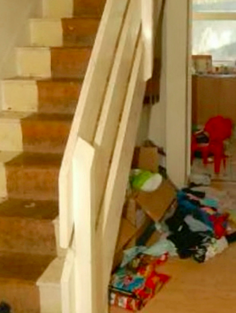 Boxes, clothes and rubbish are piled up under the stairs. (SWNS)