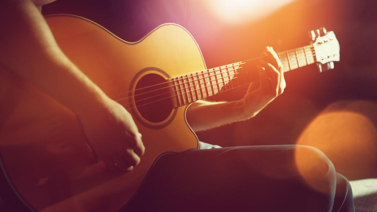  A guitarist playing an acoustic guitar. 