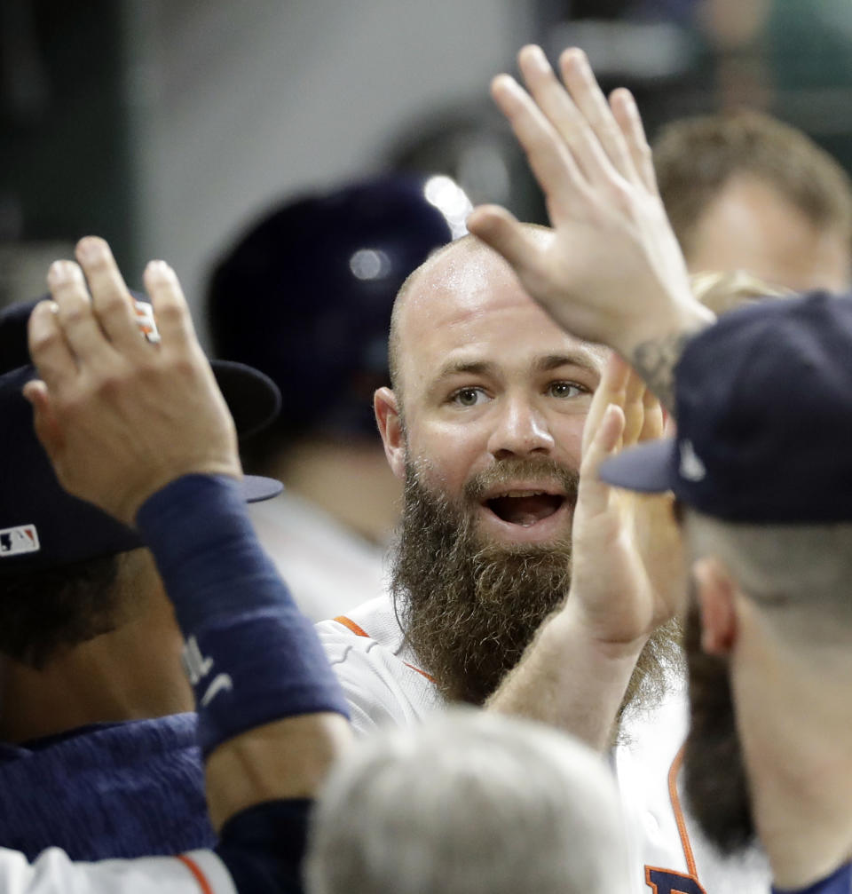Houston Astros' Evan Gattis is congratulated in the dugout after hitting a home run against the Colorado Rockies during the fifth inning of a baseball game Wednesday, Aug. 15, 2018, in Houston. (AP Photo/David J. Phillip)