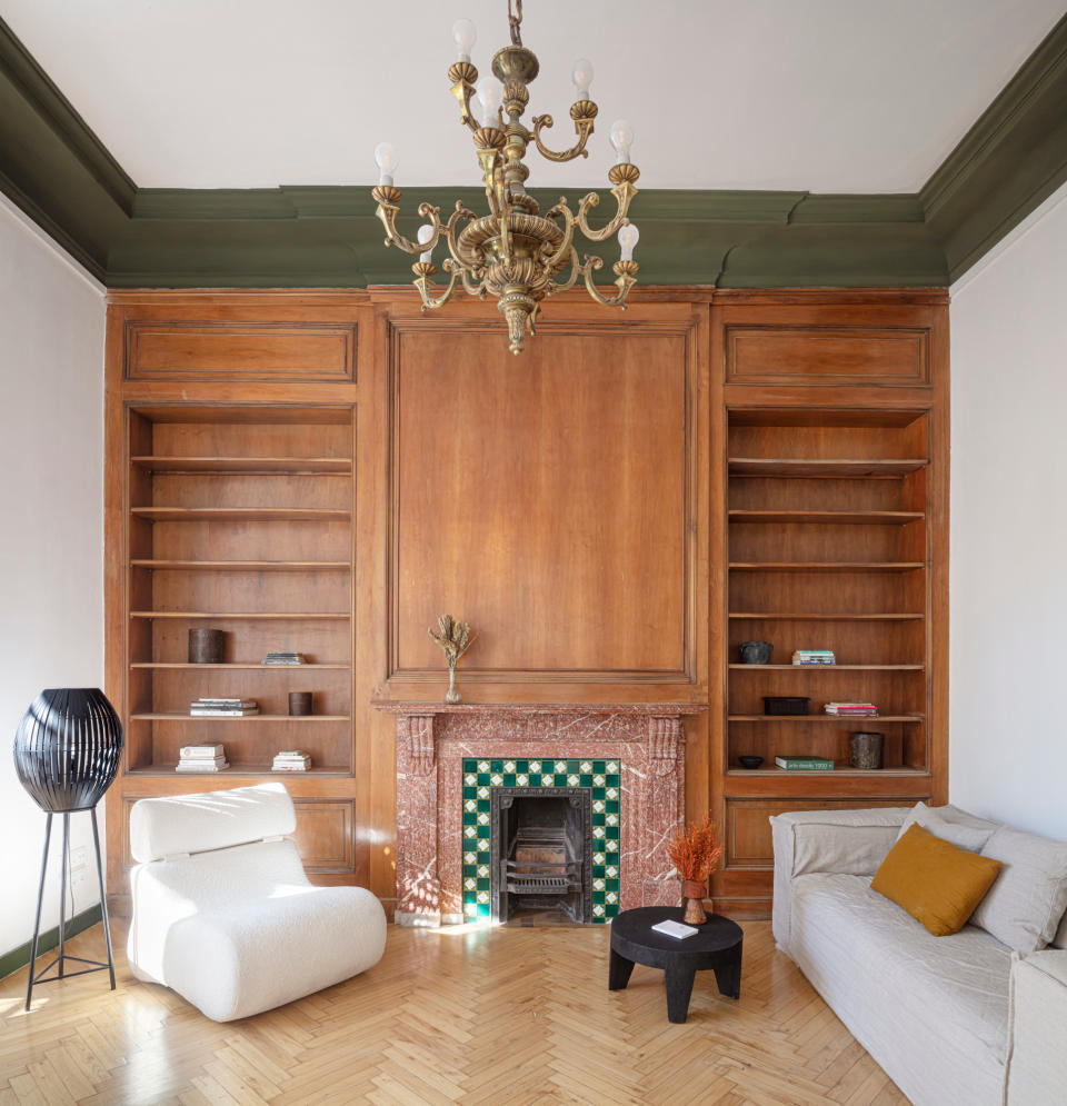 Living room with wood panelled wall and green painted coving