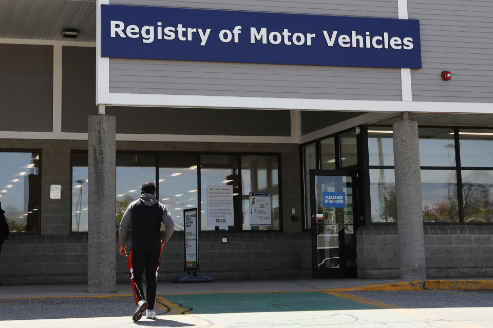 FILE - A man walks to the Commonwealth of Massachusetts Registry of Motor Vehicles office in Lawrence, Mass., Tuesday, May 5, 2020. The Massachusetts Registry of Motor Vehicle announced on Friday, Feb. 2, 2024, that it had downgraded the commercial licenses of more than two dozen drivers in the wake of a bribery scandal. (AP Photo/Charles Krupa, File)